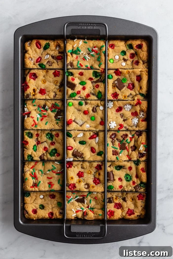 Gooey Chocolate Chip Squares 3 chocolate chip cookie bars in a slice solution pan with christmas sprinkles on top