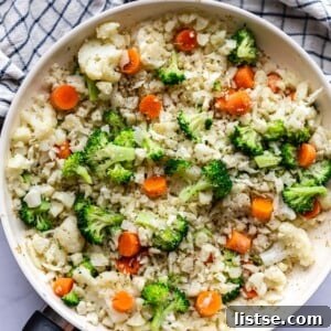skillet with cauliflower fried rice that has broccoli and carrots in it