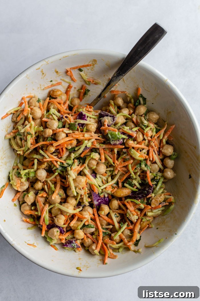 Savory Peanut Chickpea Wraps 4 A large white bowl filled with a vibrant mix of chickpeas and coleslaw, generously coated in a creamy peanut sauce, ready for assembly.
