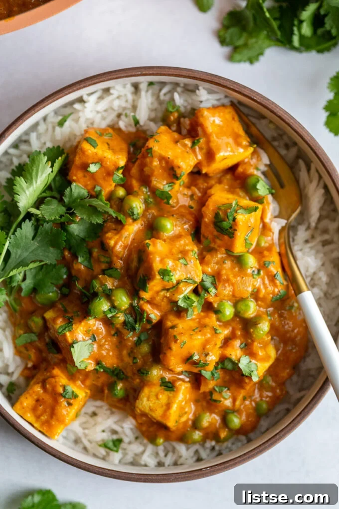 A large bowl of creamy Tofu Tikka Masala, garnished generously with fresh cilantro, ready to be served