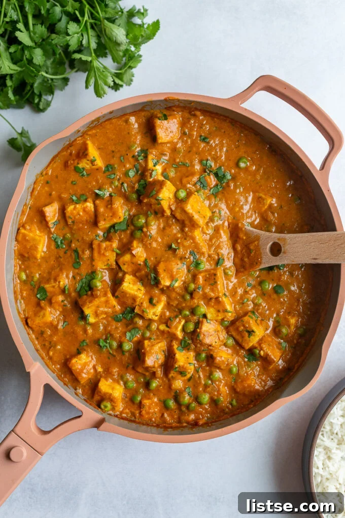 Tofu Tikka Masala simmering in a vibrant pink skillet, showcasing its rich, creamy texture and inviting colors
