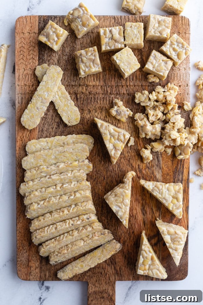 tempeh on a wood cutting board and cut into several different shapes