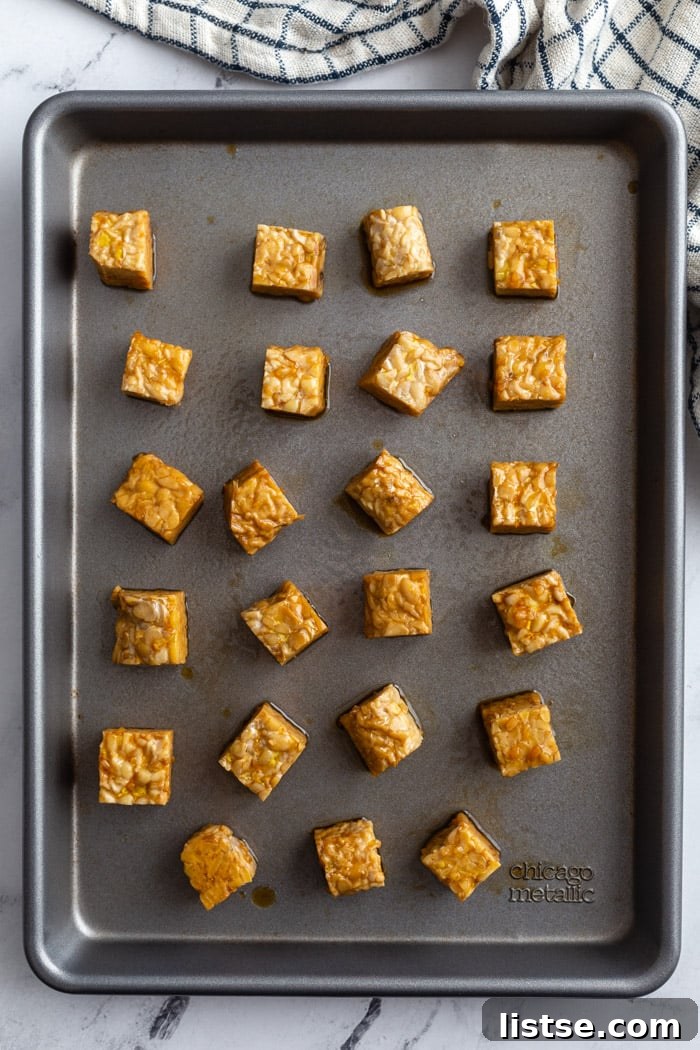 baked tempeh lined up on a baking tray