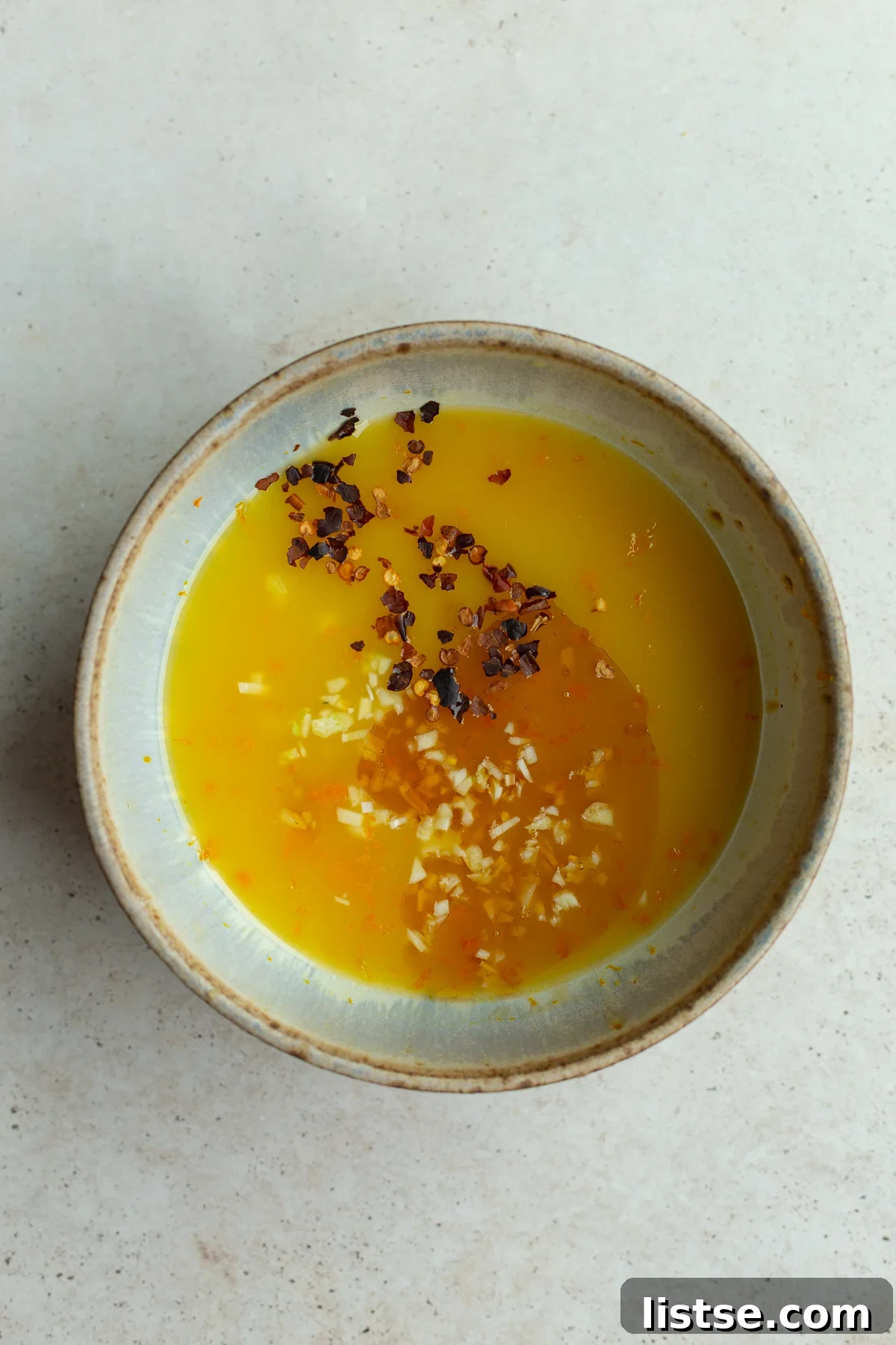 Ingredients for the orange sauce whisked together in a small bowl.