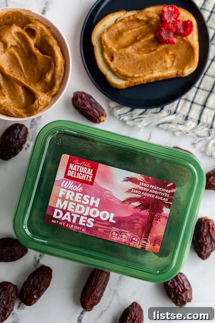 Natural Date Sweetener 3 A large tub of Natural Delights Medjool dates, with several loose dates scattered around it on a wooden surface.