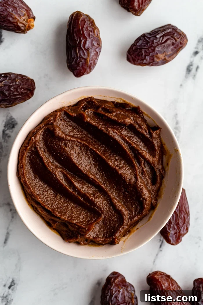 Natural Date Sweetener 5 A bowl of creamy, chocolate-infused date paste, garnished with a few fresh dates.