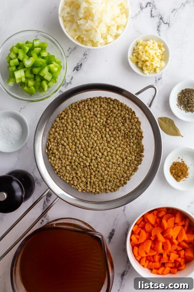 A collection of fresh ingredients laid out, including green split peas, diced vegetables, and various spices, ready for making soup.