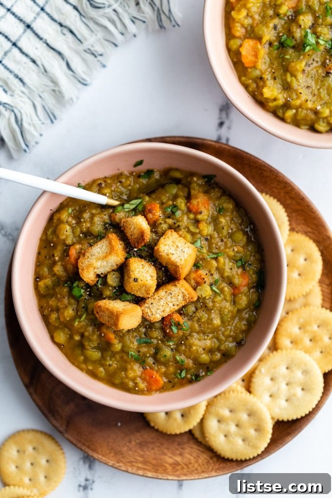 A bowl of vegan split pea soup served with a side of crispy crackers, emphasizing a comforting and satisfying meal.