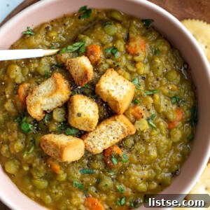 A steaming bowl of vegan split pea soup, garnished with crispy croutons, invitingly ready to be enjoyed.
