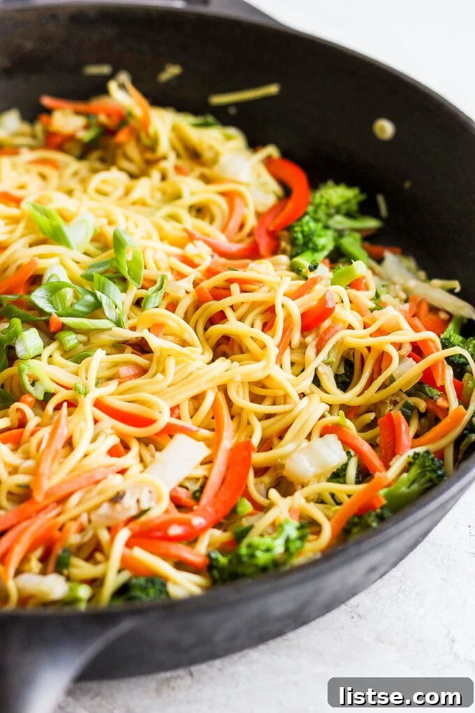 Vegetable chow mein simmering in a large skillet or wok, ready to be served.