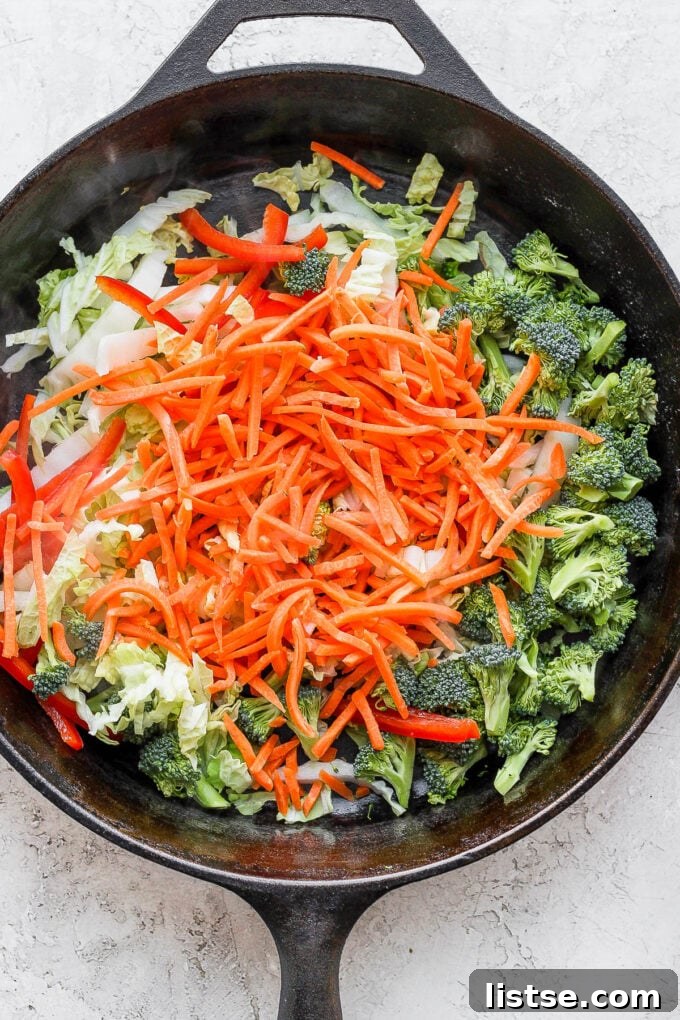 Close-up of chopped carrots, broccoli, and bell pepper ready for stir-frying.