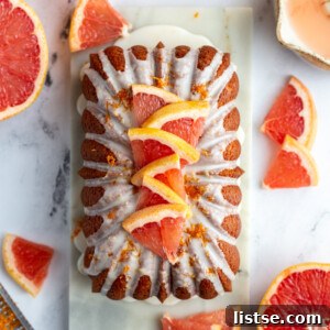 Zesty Vegan Grapefruit Loaf 10 Iced grapefruit loaf topped with slices of grapefruit and more grapefruit around the loaf