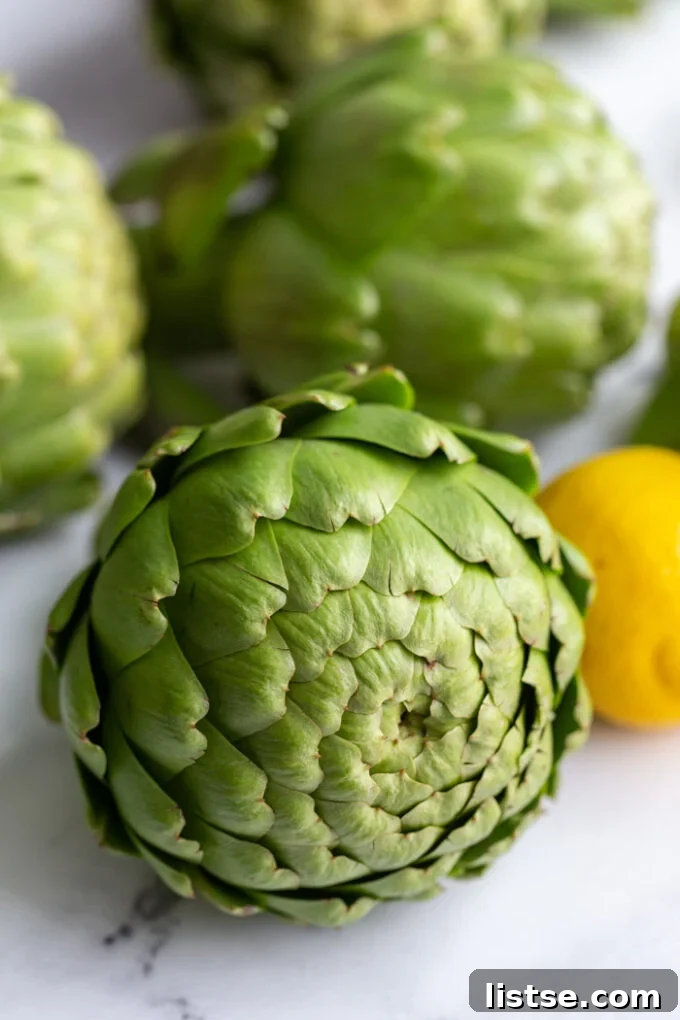 A close-up of two fresh artichokes, ready for preparation, emphasizing their natural texture and form.