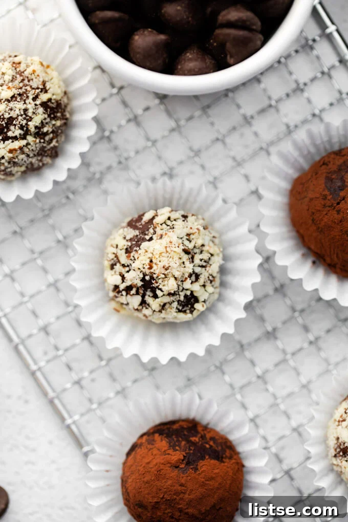 Amaretto Dream Truffles 2 Decadent Amaretto Chocolate Truffles coated in nuts, presented elegantly in mini muffin liners with more truffles scattered around.