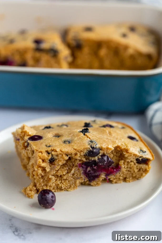 Baked Oats Double the Delight 5 slice of baked oats in a plate with the casserole dish of the rest of the baked oats in the background