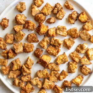 A square image showing golden brown, crispy air fryer tofu.