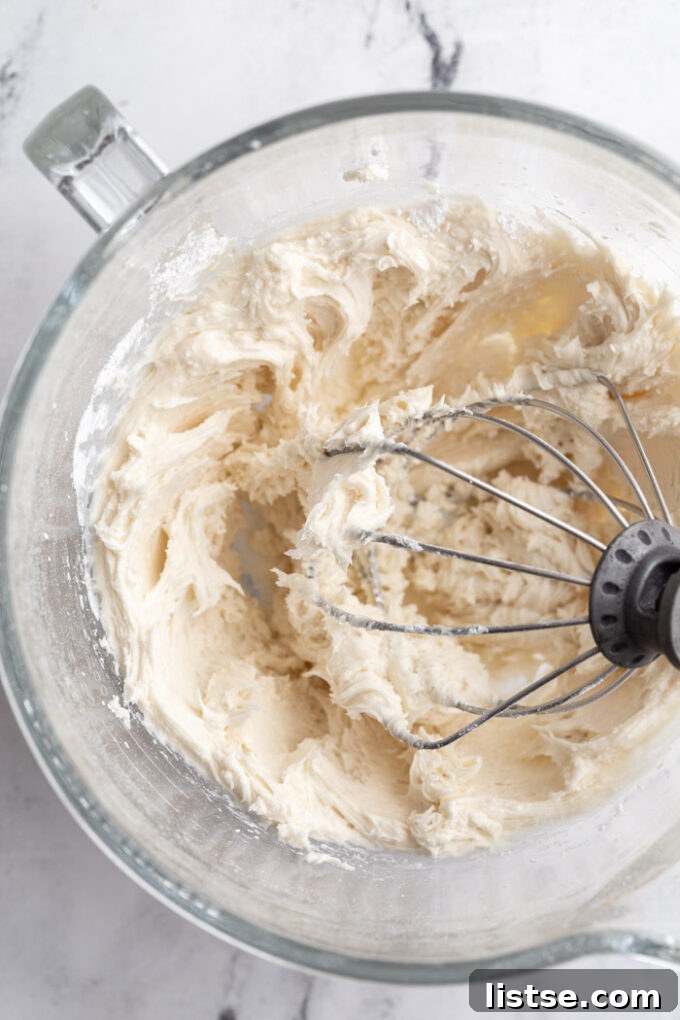 Creamy buttercream cookie frosting being prepared in a stand mixer, ready for your favorite cookies.