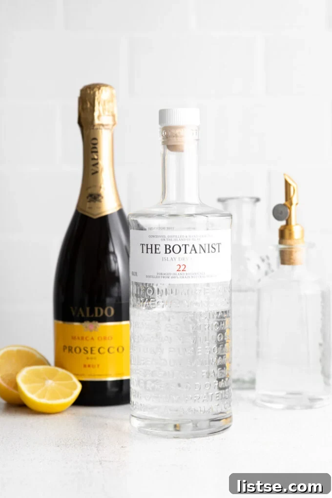 Ingredients laid out for making a French 75 Cocktail recipe: gin, lemon, simple syrup, and champagne