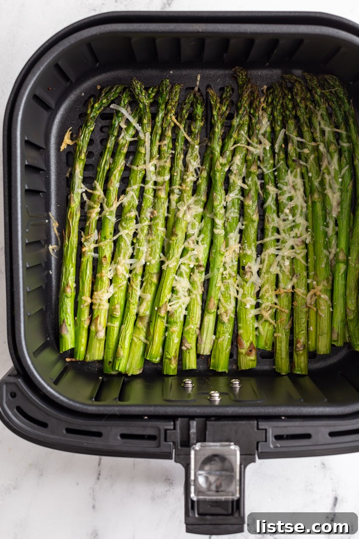 Air fryer asparagus cooked to perfection and topped with cheese, ready to serve