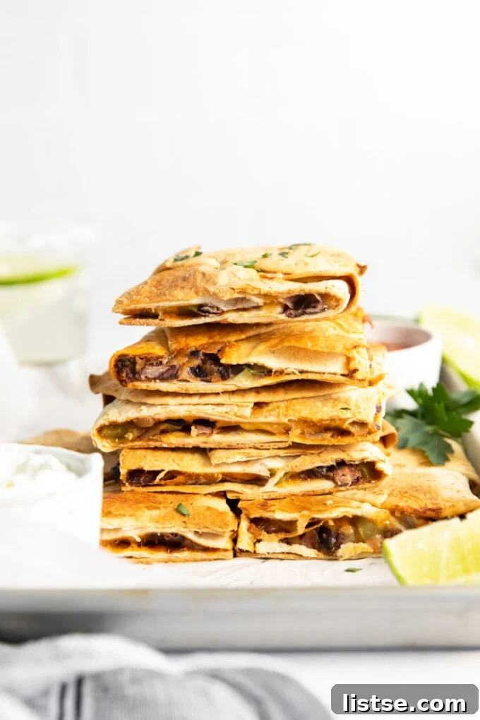 Crispy vegetarian quesadillas stacked high, revealing their delicious black bean, cheese, and vegetable filling.
