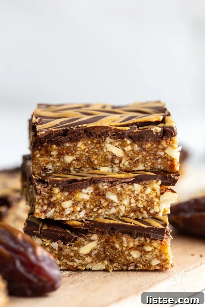 date and nut bars topped with chocolate and peanut butter drizzle. 3 bars stacked on top of each other