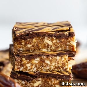 date and nut bars topped with chocolate and peanut butter drizzle. 3 bars stacked on top of each other
