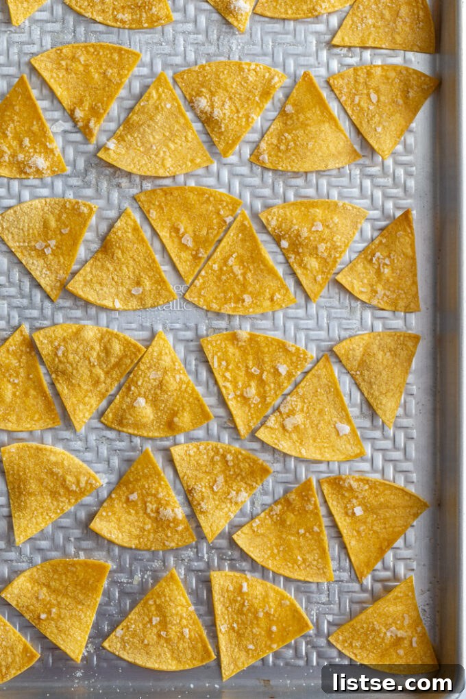 homemade tortilla chips lined up on a baking sheet