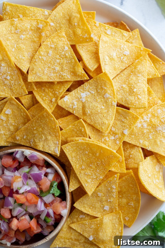 large plate of homemade tortilla chips with a bowl of pico de gallo on the plate
