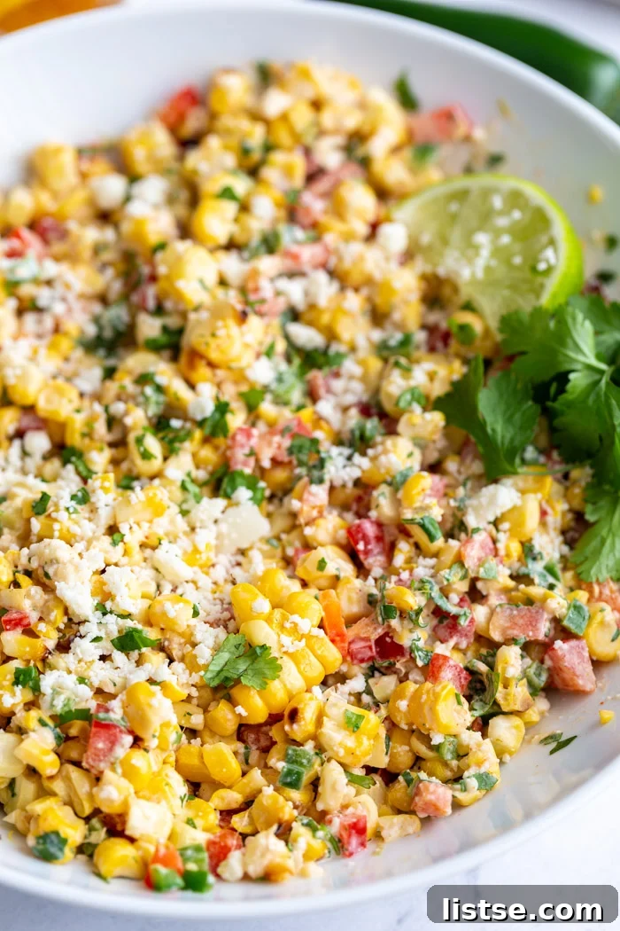 Creamy Mexican Street Corn Salad 3 Another perspective of the large white bowl of Mexican Street Corn Salad, Esquites, showcasing its rich texture and colorful ingredients like grilled corn kernels, cotija cheese, and fresh herbs.