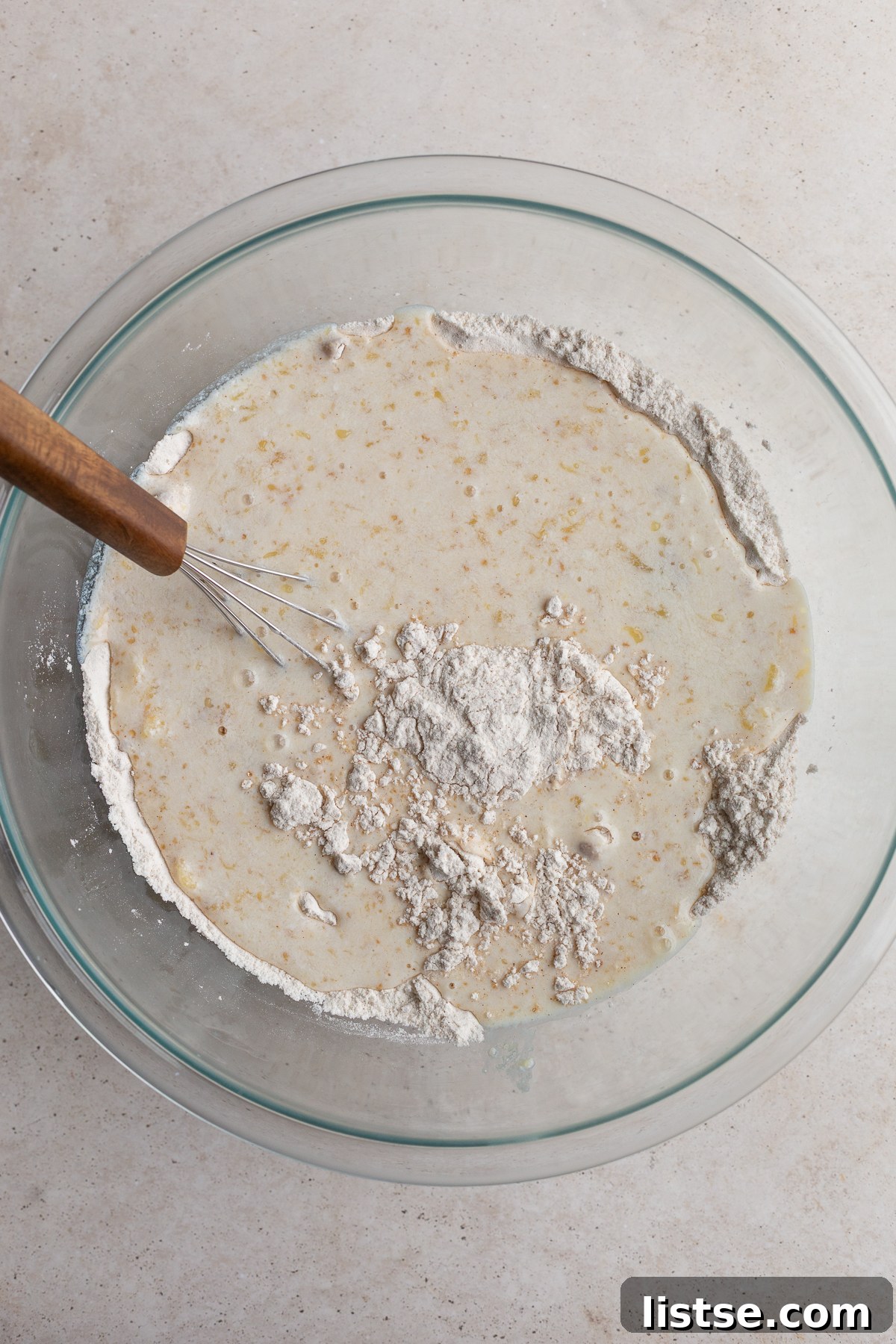 A large bowl containing vegan waffle batter being mixed, showing a few lumps which are perfectly normal.