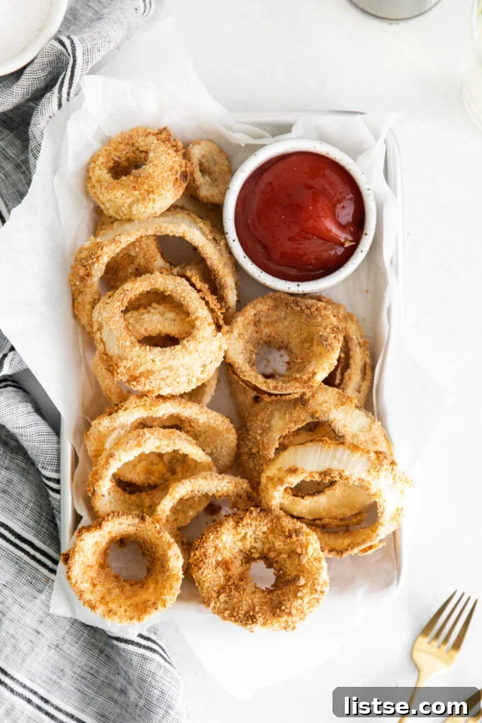Crispy Air Fryer Onion Rings served with ketchup, showcasing their golden-brown perfection.