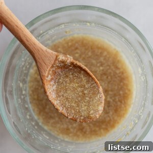Flax egg in a small bowl with a wooden spoon in it, ready for baking.