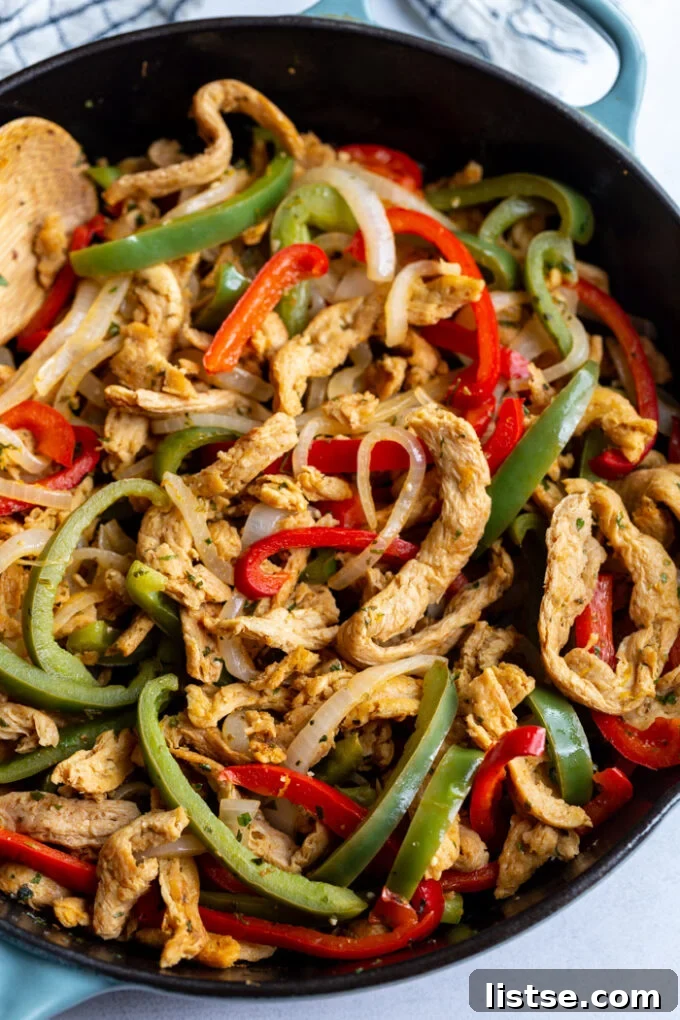 soy curls fajitas with soy curls and sauteed onion and green + red bell pepper in a large cast iron skillet