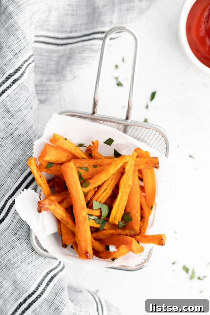 A second shot of a basket filled with air-fried carrot fries, garnished with fresh herbs, ready to be served.