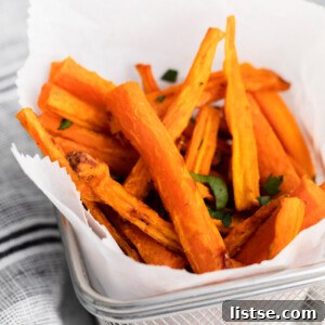 A rustic basket lined with parchment paper, filled with crispy air-fried carrot fries, lightly seasoned with fresh herbs, ready for serving.