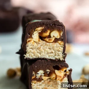 Homemade Snickers candy bar cut in half, showcasing layers