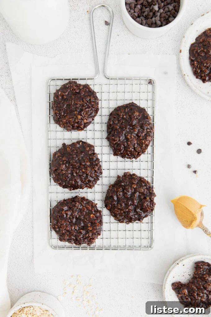 Vegan No Bake Cookies on a wire rack next to a spoon with peanut butter