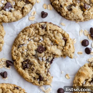 chocolate chip oatmeal cookies on parchment paper with oats and chips surrounding it