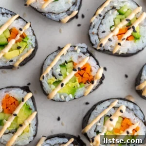 Cucumber rolls drizzled with spicy mayo, arranged on a plate.