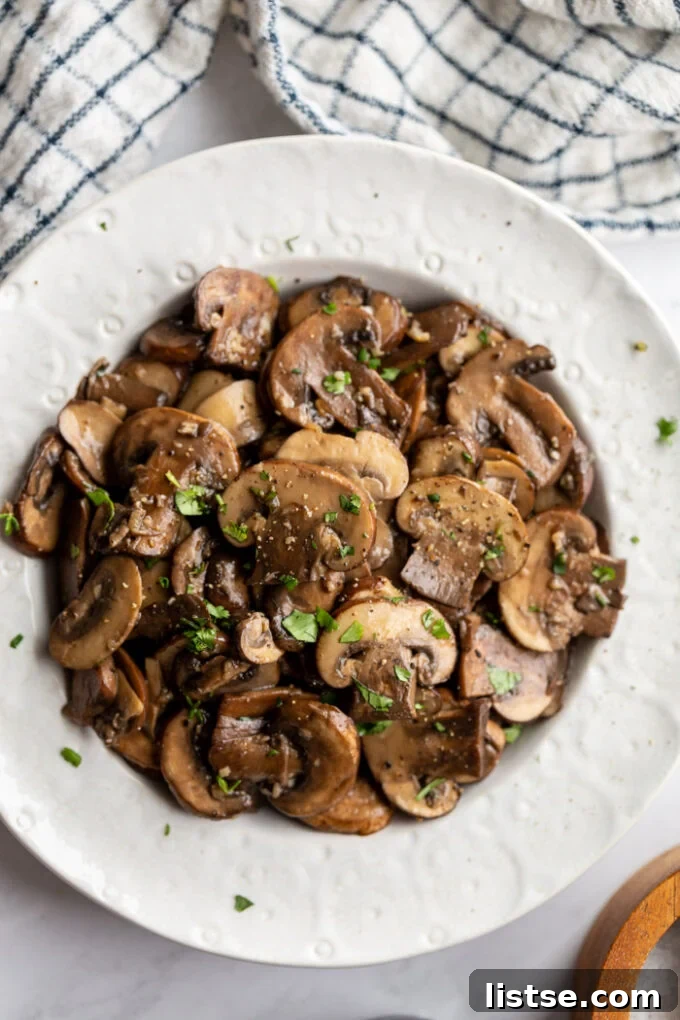 Sautéed cremini mushrooms presented beautifully in a white serving bowl, ready to be enjoyed.
