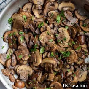 Sautéed cremini mushrooms cooking in a large skillet