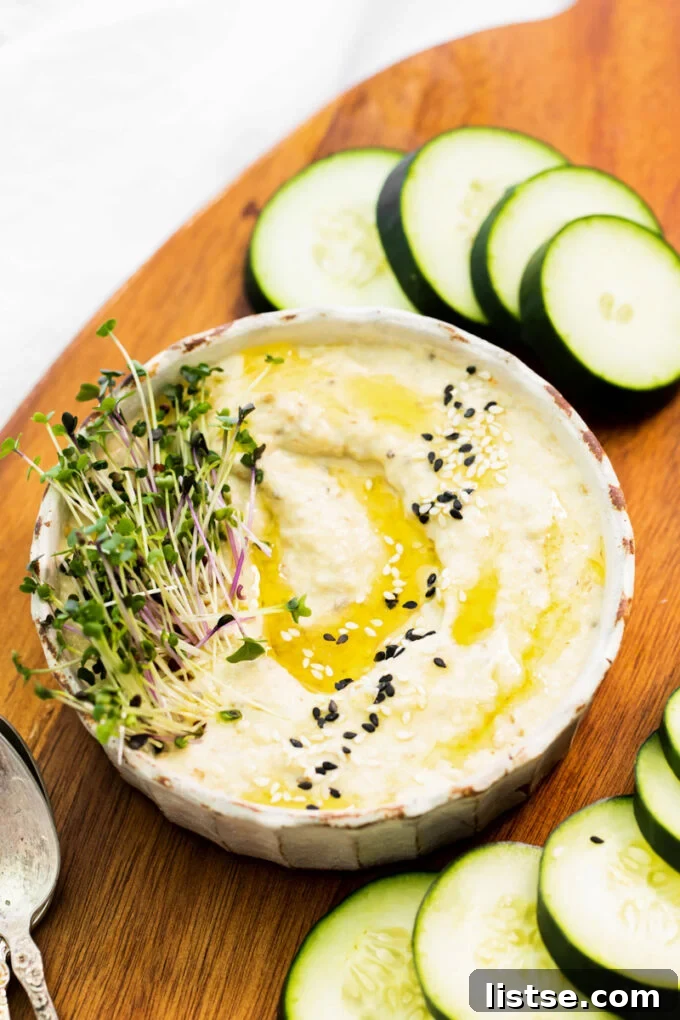 Close-up of Baba Ganoush garnished with fresh green sprouts and a drizzle of olive oil, ready to serve