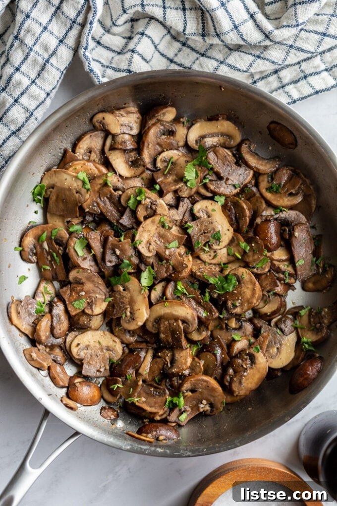 baby Bella mushrooms sautéing in a large skillet
