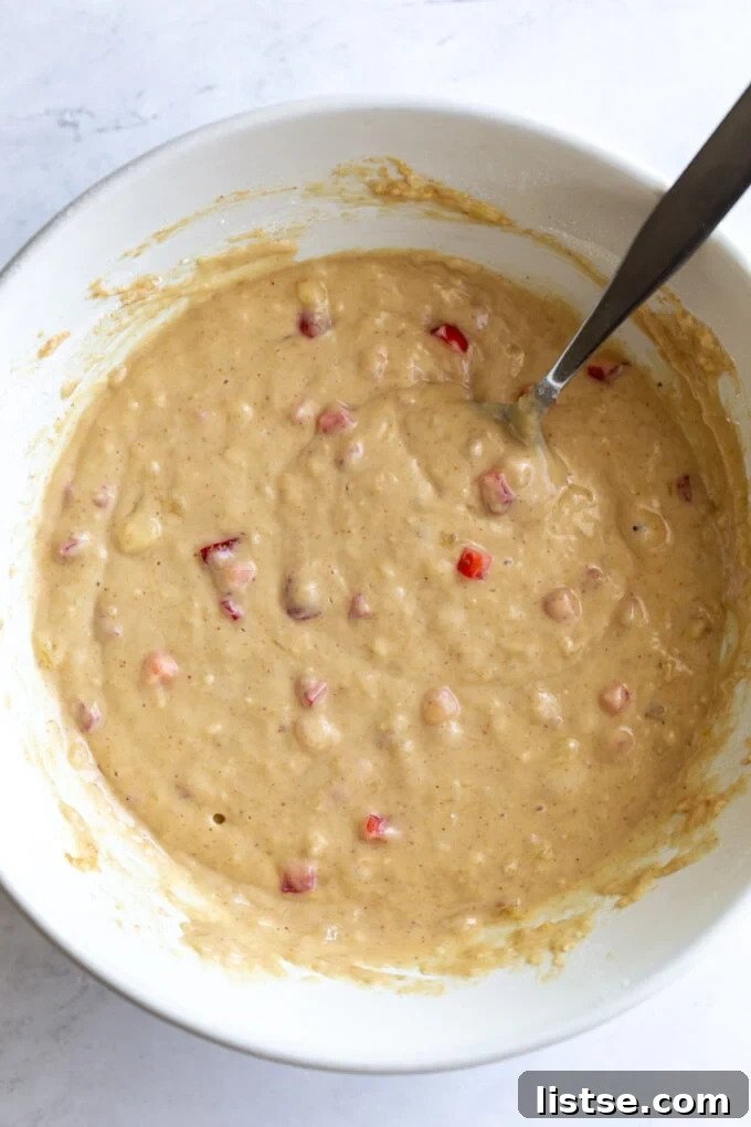 A large white bowl filled with creamy vegan strawberry donut batter, ready for piping.