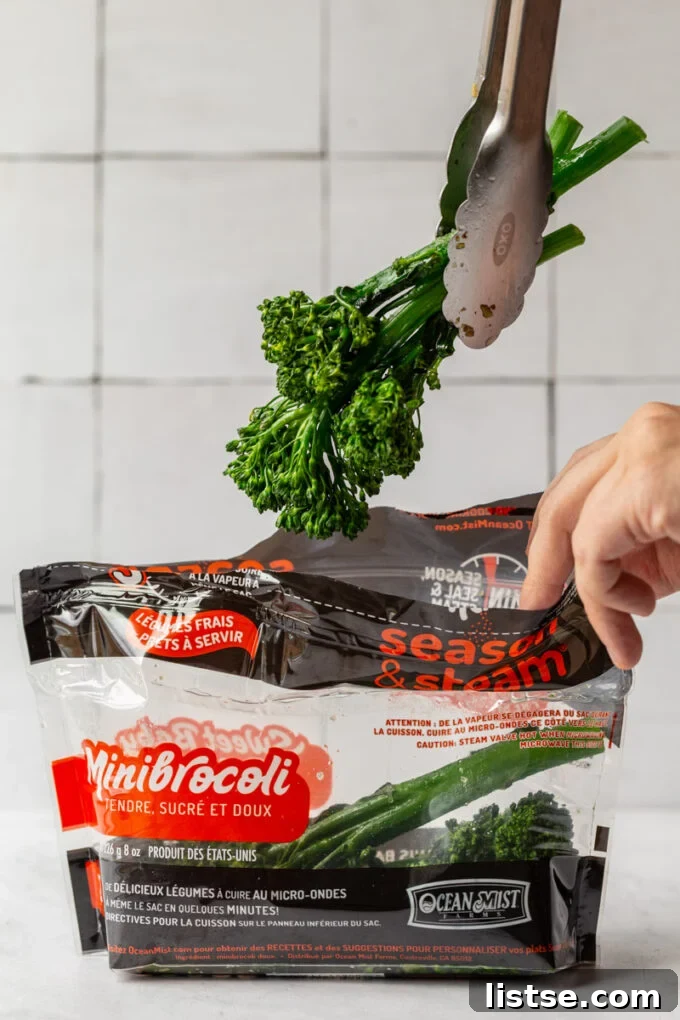 Grilled Summer Salad 3 A hand pulling sweet baby broccoli out of an Ocean Mist Season & Steam bag, ready for a delicious meal.