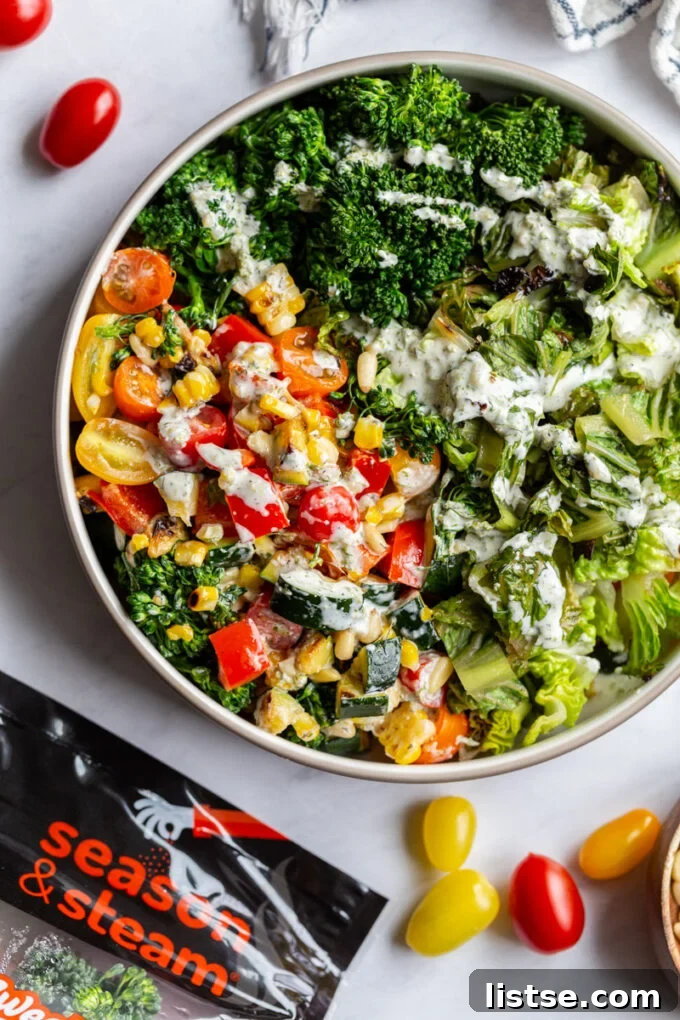 Grilled Summer Salad 4 A large, inviting bowl of grilled salad, featuring mixed vegetables and romaine, with a package of Season and Steam veggies subtly placed nearby.