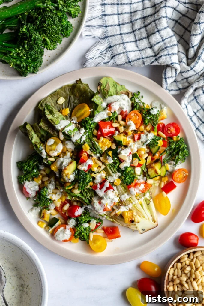 Grilled Summer Salad 6 Close-up of a beautifully arranged grilled romaine lettuce, generously topped with a colorful mix of grilled summer vegetables and a luscious white dressing.