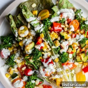 grilled romaine lettuce topped with mixed veggies and a white salad dressing