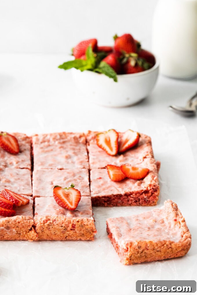 Strawberry Chocolate Bliss 10 Strawberry brownies adorned with a sweet glaze and fresh strawberries, arranged beautifully.