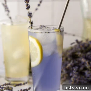 lavender lemonade in a glass with a slice of lemon and a sprig of lavender